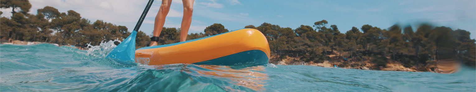 Un stand up paddle avec bordure orange sur une eau claire