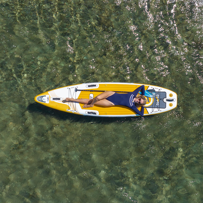 Femme allongé sur son stand up paddle de couleur jaune et blanc