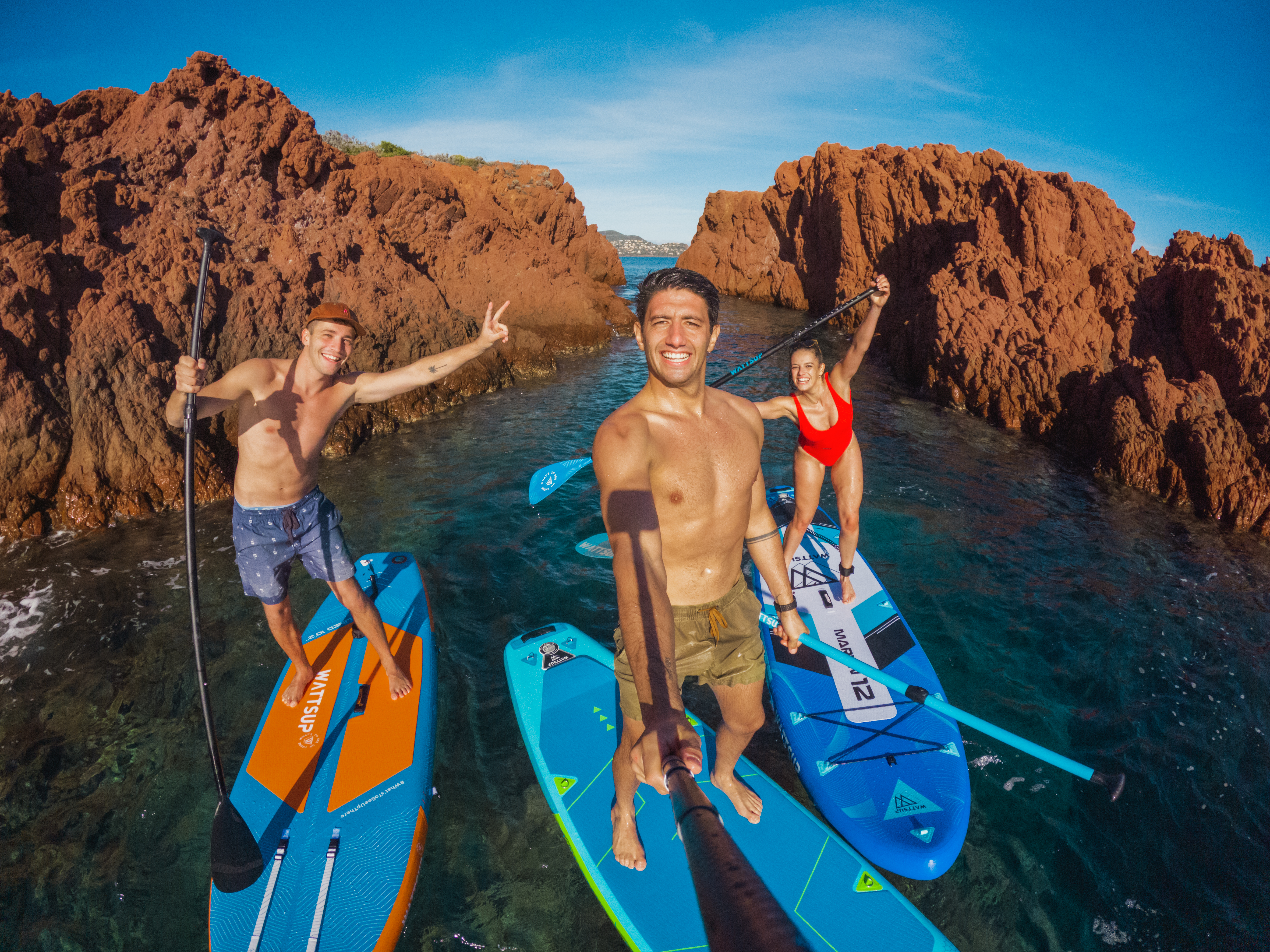 Trois jeunes hommes sur des planches gonflables en mer