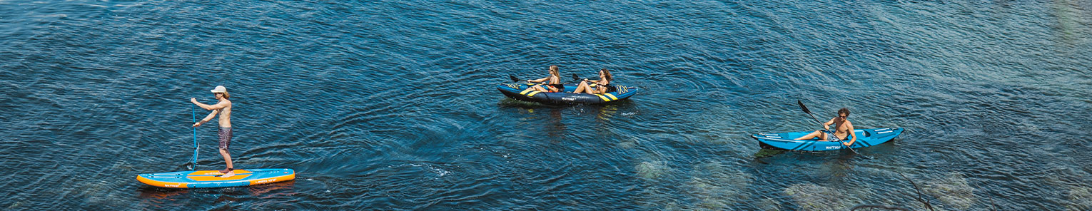 Image d'un stand up paddle bleu et orange sur la mer et deux kayaks gonflables bleu